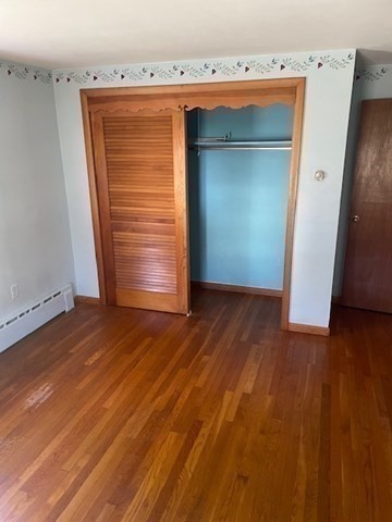 52 Peach Hill Road Berlin, MA 01503 - Photo 18 of 27 an empty room with wooden floor and cabinet