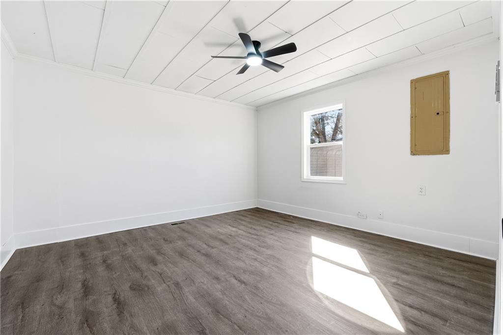 34 Wade Street Winder, GA 30680 - Photo 12 of 22 an empty room with wooden floor ceiling fan and windows