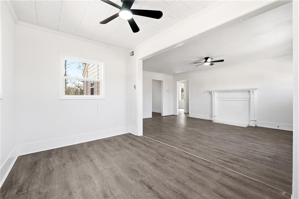 34 Wade Street Winder, GA 30680 - Photo 6 of 22 an empty room with wooden floor ceiling fan and windows