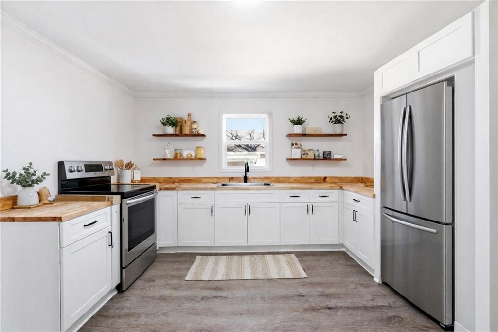 34 Wade Street Winder, GA 30680 - Photo 8 of 22 a kitchen with white cabinets and stainless steel appliances
