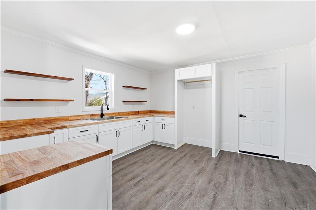 34 Wade Street Winder, GA 30680 - Photo 10 of 22 a large white kitchen with granite countertop a stove top oven a sink and white cabinets with wooden floor