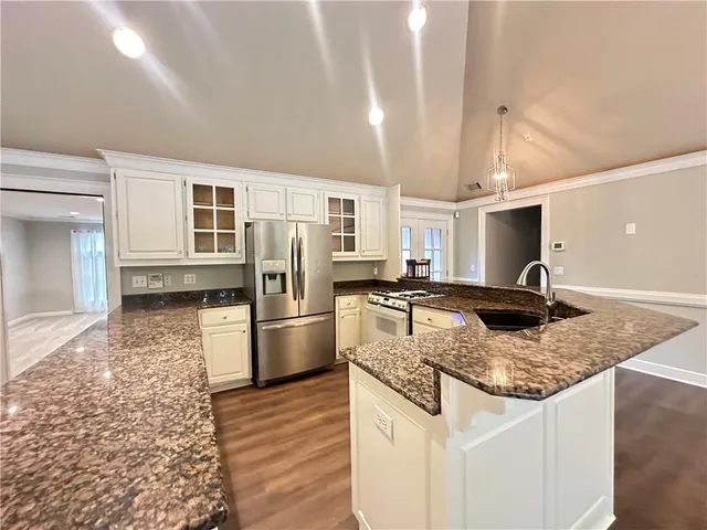 a kitchen with stainless steel appliances granite countertop a sink stove and refrigerator