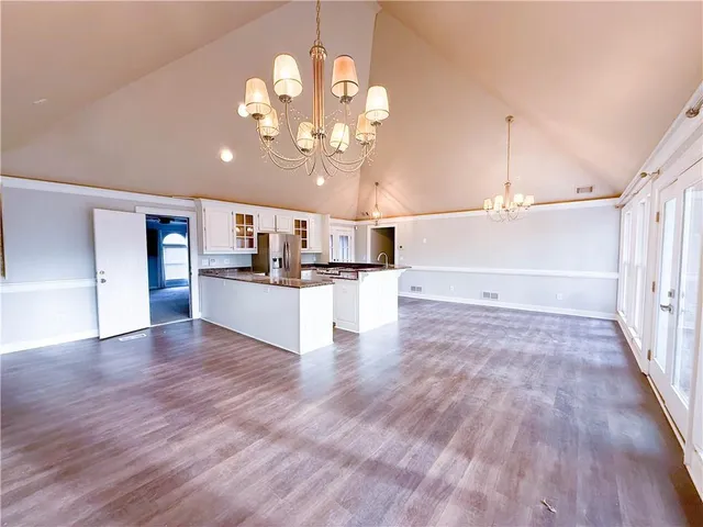 a view of a kitchen with a sink and dishwasher with wooden floor