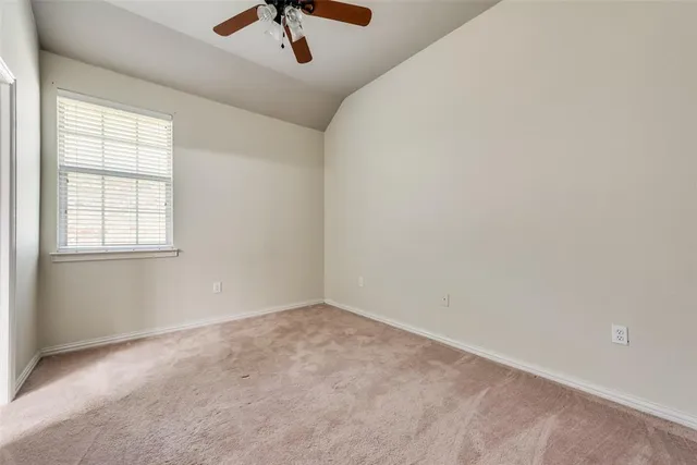 an empty room with a window and a ceiling fan