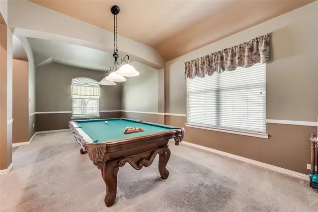 a room with pool table and windows