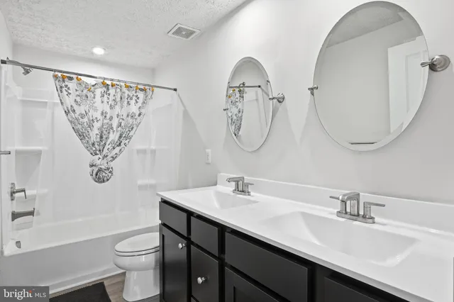 an empty room with wooden floor ceiling fan and window