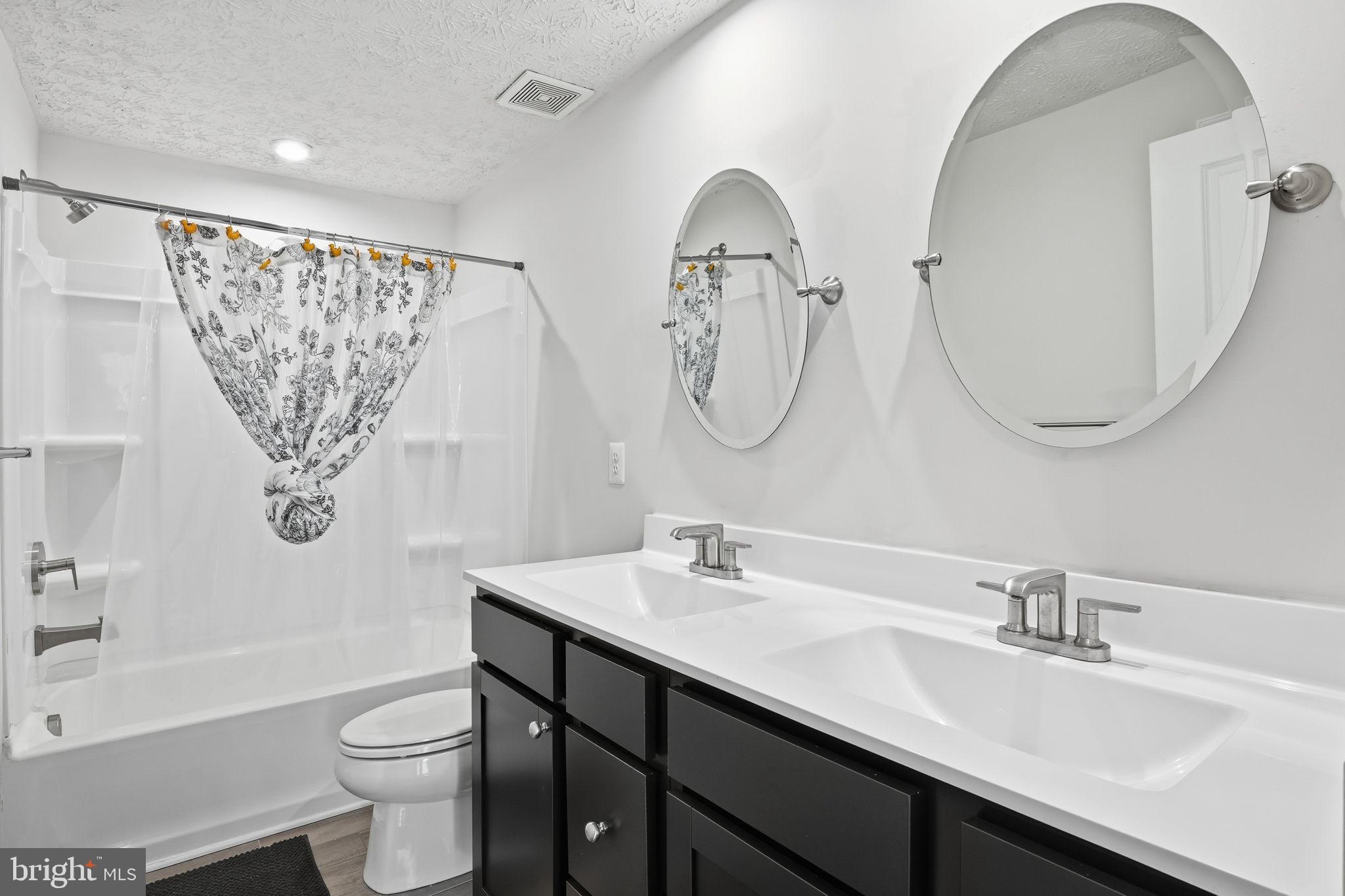 474 Ruffian Court Annapolis, MD 21409 - Photo 14 of 36 a bathroom with a double vanity sink toilet and a mirror