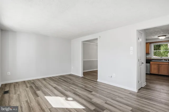 a view of a room with wooden floor and a sink