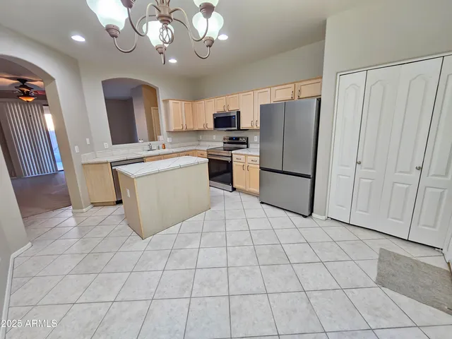 a kitchen with stainless steel appliances granite countertop a refrigerator and a stove top oven