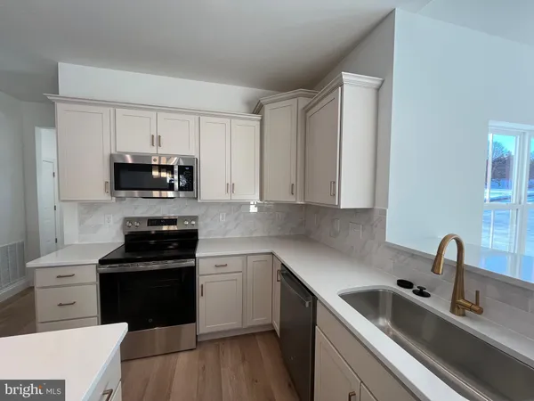 a kitchen with cabinets stainless steel appliances a sink and a counter top space