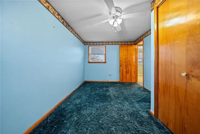 a view of a big room with chandelier fan and windows