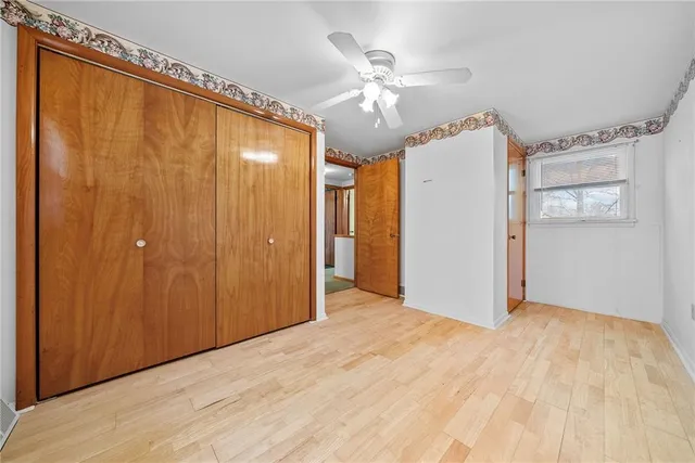 a view of a big room with wooden floor and chandelier fan