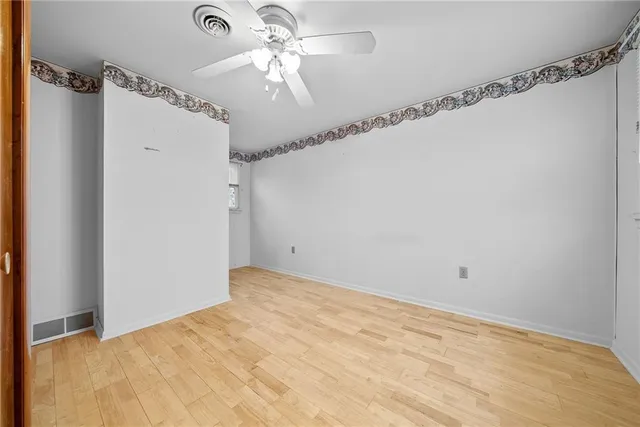 a view of a big room with carpet and a chandelier fan