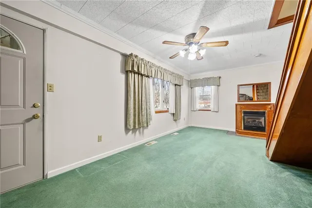 an empty room with windows and ceiling fan