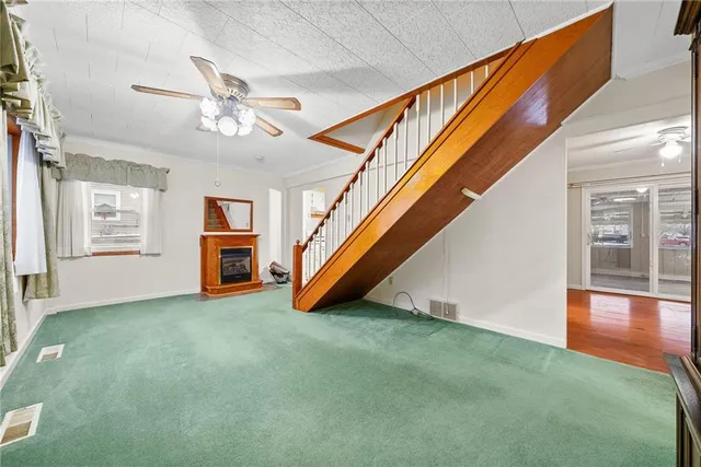 an empty room with windows and ceiling fan