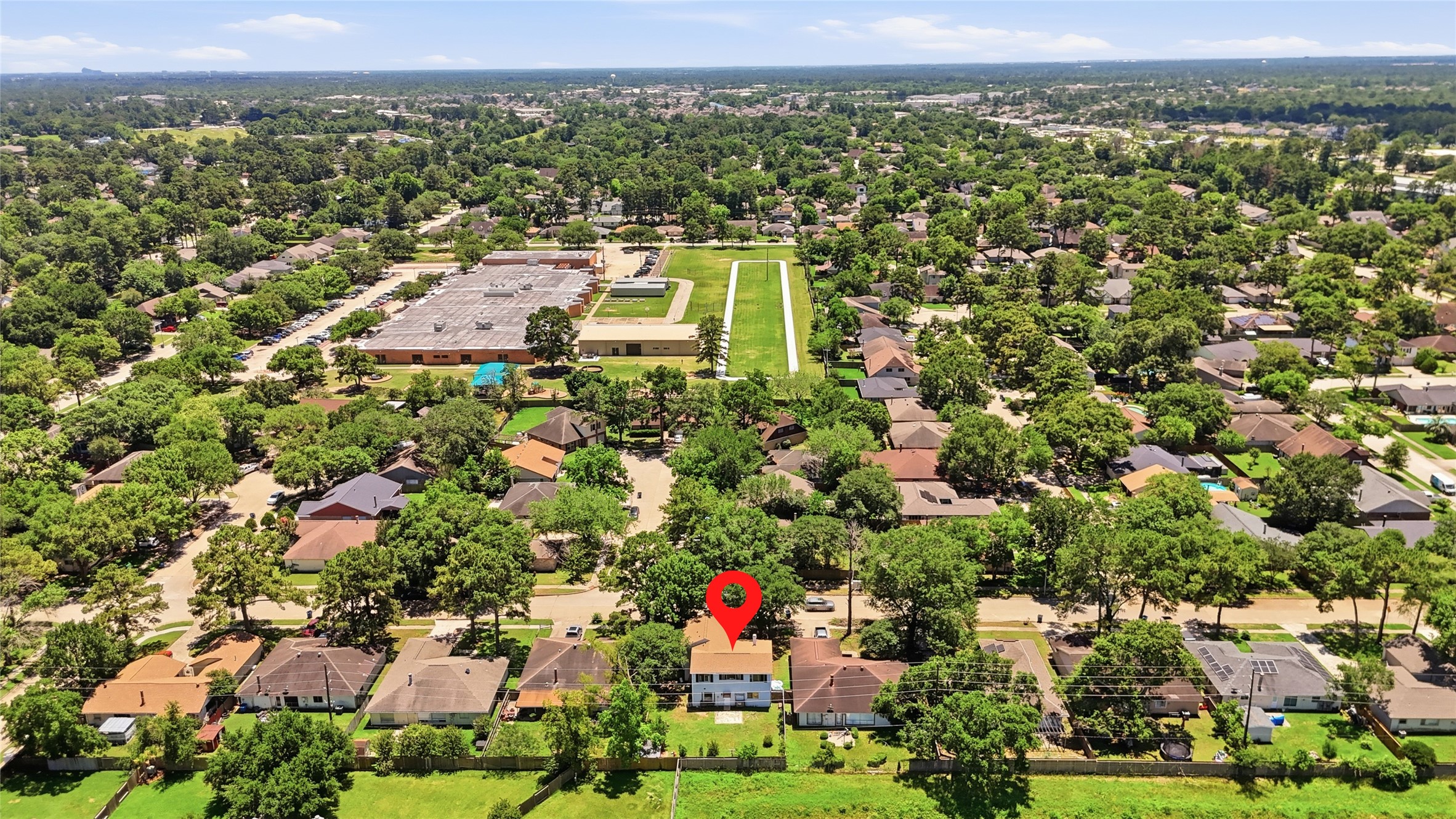 4718 Temple Bell Drive Spring, TX 77388 - Photo 47 of 50 This aerial photo shows a suburban neighborhood with tree-lined streets and a mix of single-story homes. The highlighted property is centrally located, offering easy access to nearby schools and amenities, surrounded by greenery and open spaces.