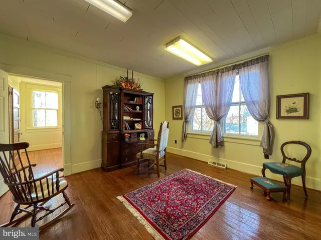a view of a room with wooden floor and furniture
