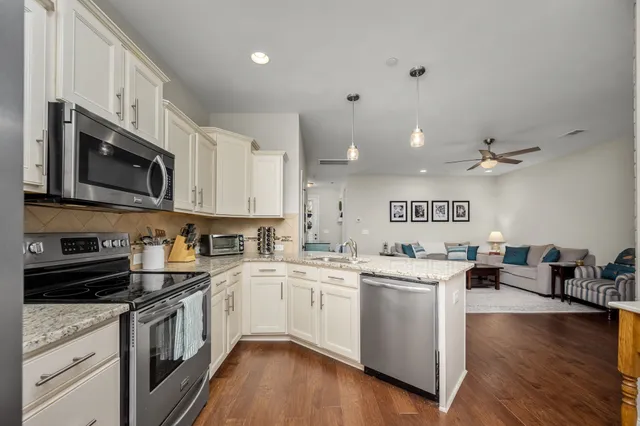 a dining room with stainless steel appliances kitchen island granite countertop a dining table chairs and granite counter tops