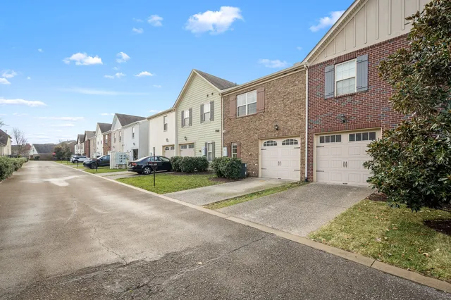 an aerial view of residential houses with outdoor space and parking