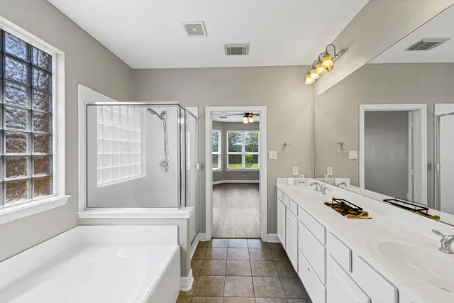 a bathroom with a tub sink and mirror