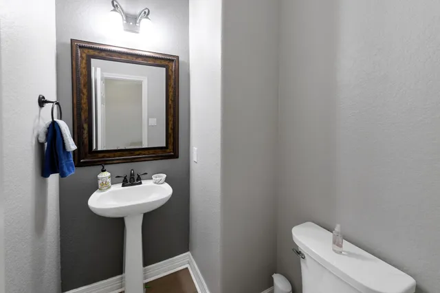 a bathroom with a toilet sink and mirror