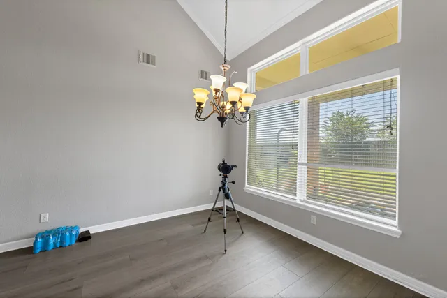 a view of a room with a large window and wooden floor