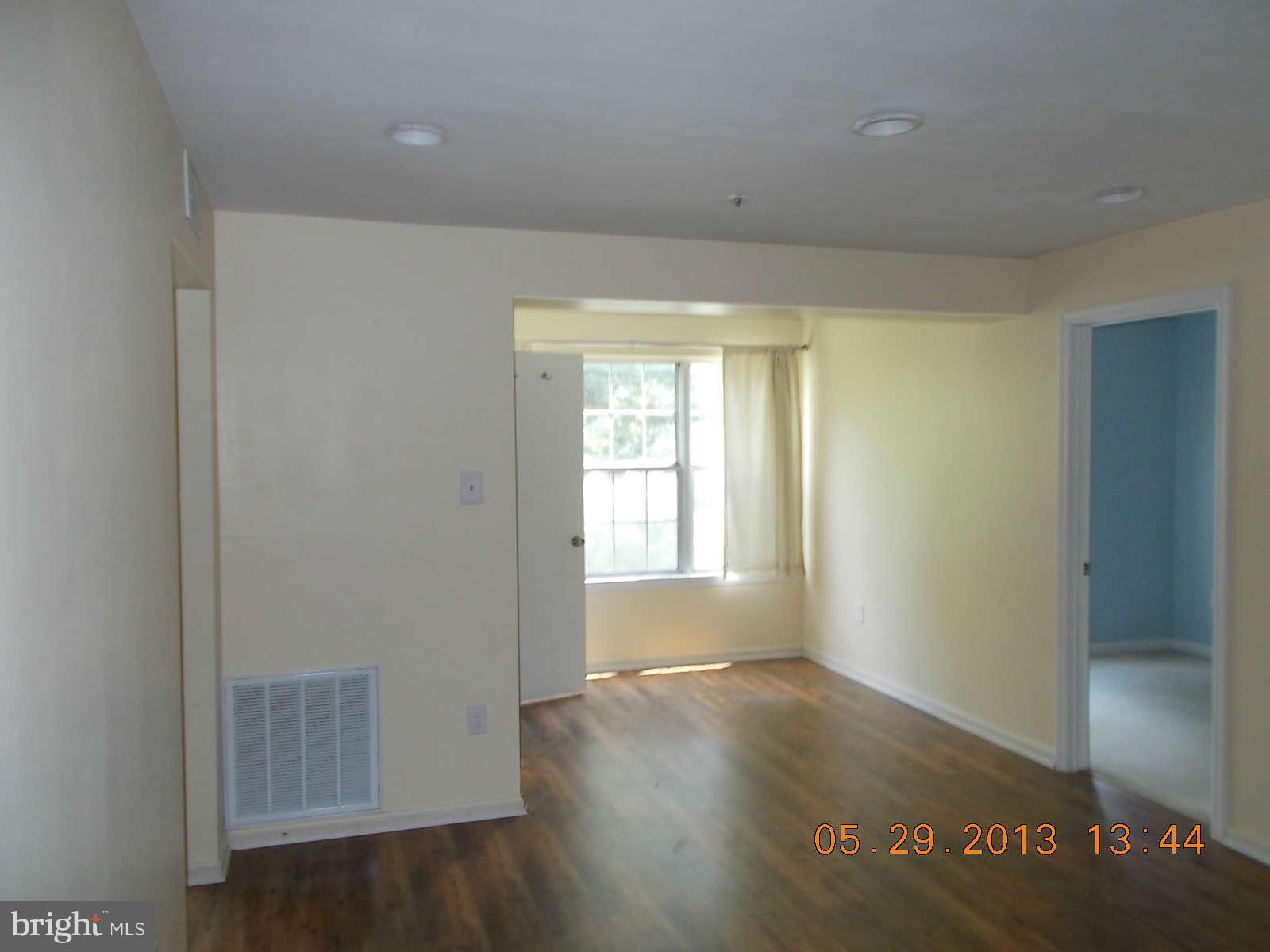 14913 Cleese Court, Unit C Silver Spring, MD 20906 - Photo 8 of 20 a view of an empty room with wooden floor and a window