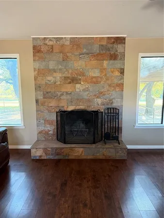 an empty room with wooden floor and a fireplace