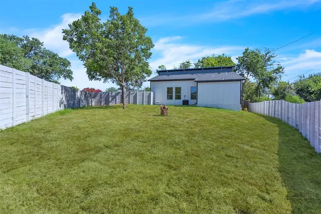 a view of a house with a yard and a tree