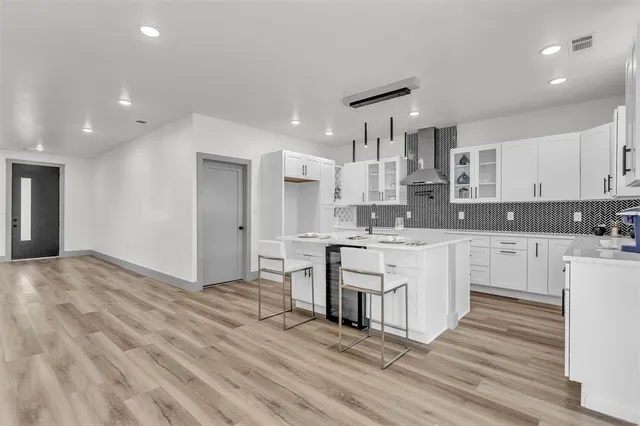 a large kitchen with kitchen island white cabinets and stainless steel appliances