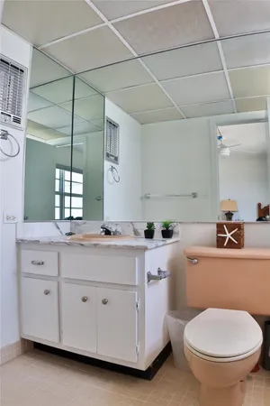 a bathroom with a granite countertop toilet a sink and a mirror