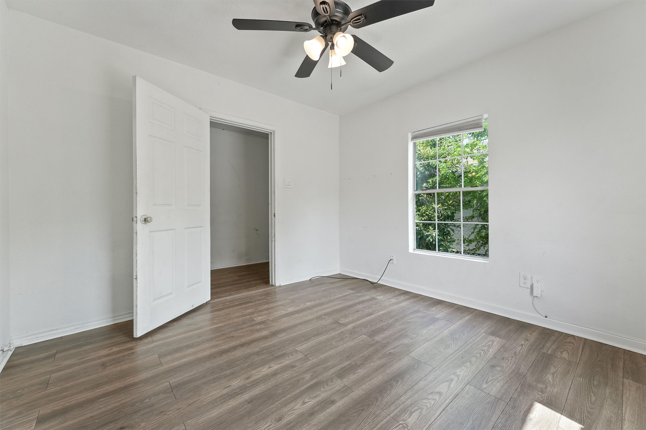 3019 Florida Street, Unit 3 Houston, TX 77026 - Photo 7 of 14 an empty room with wooden floor chandelier fan and windows