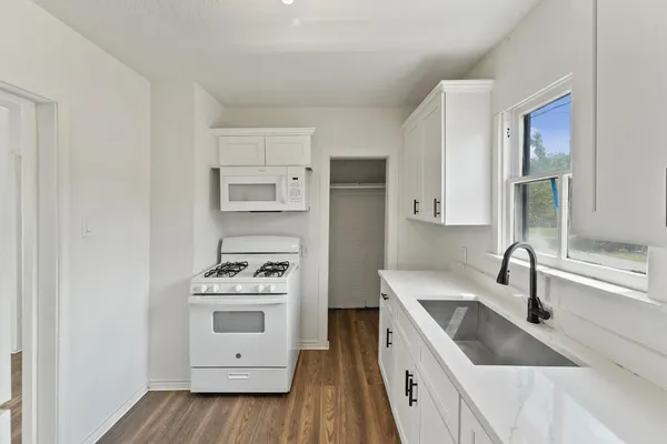 a kitchen with a refrigerator sink and cabinets