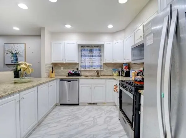 a kitchen with stainless steel appliances granite countertop a stove sink and cabinets