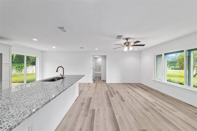 a kitchen with granite countertop white cabinets and a sink