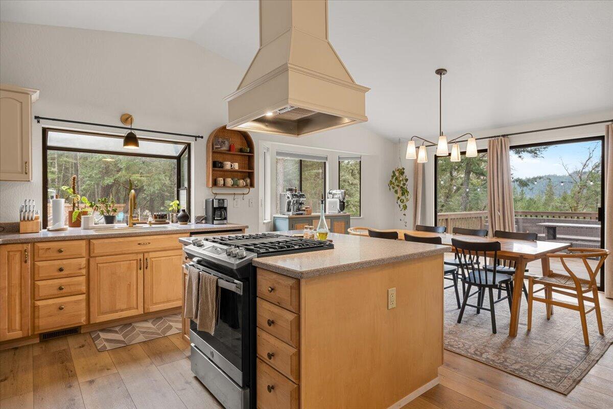 350 Splendor Drive Wilderville, OR 97543 - Photo 17 of 57 a kitchen with a stove a sink a dining table and chairs