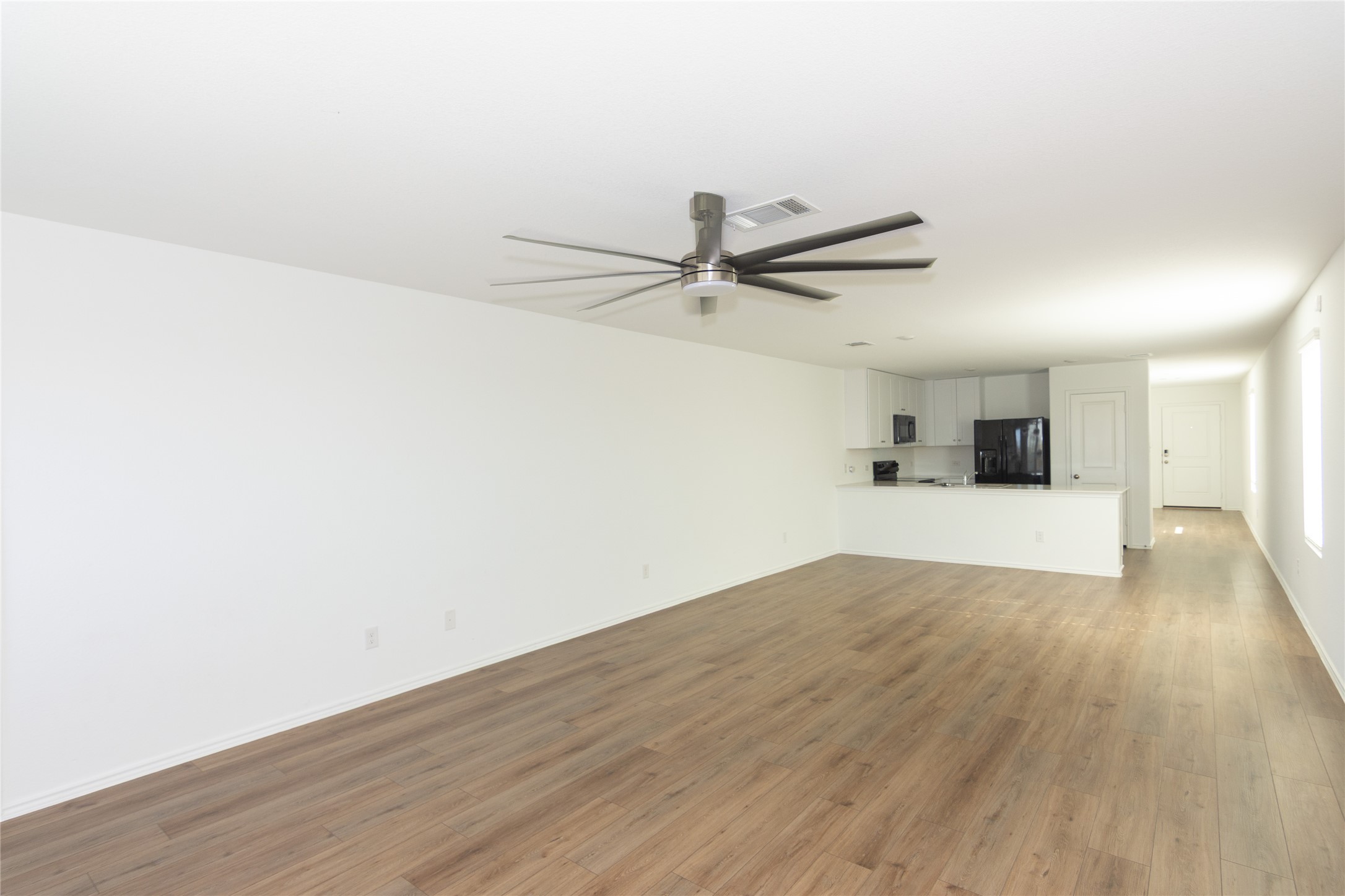 544 Rancho Del Cielo Loop Jarrell, TX 76537 - Photo 12 of 39 Unfurnished living room featuring ceiling fan and dark wood finished floors