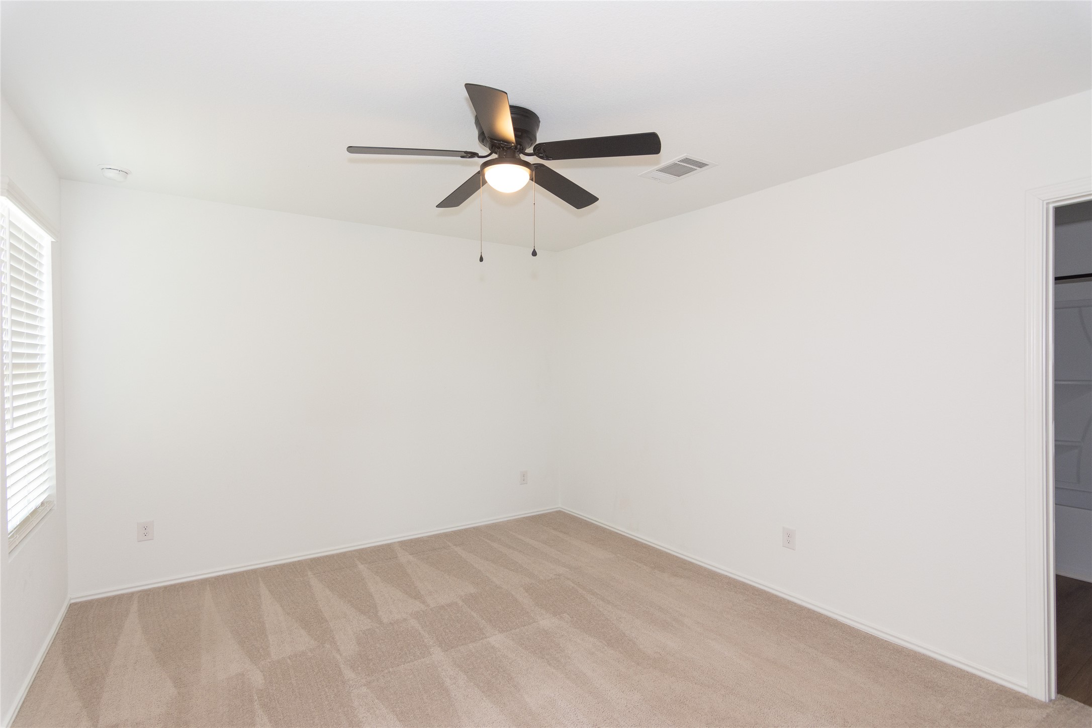 544 Rancho Del Cielo Loop Jarrell, TX 76537 - Photo 14 of 39 Unfurnished bedroom with ceiling fan, light colored carpet, and a spacious closet