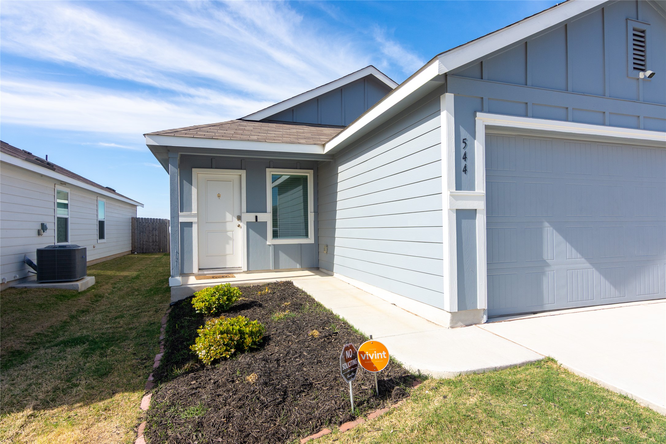544 Rancho Del Cielo Loop Jarrell, TX 76537 - Photo 2 of 39 View of front facade with board and batten siding, an attached garage, driveway, and roof with shingles