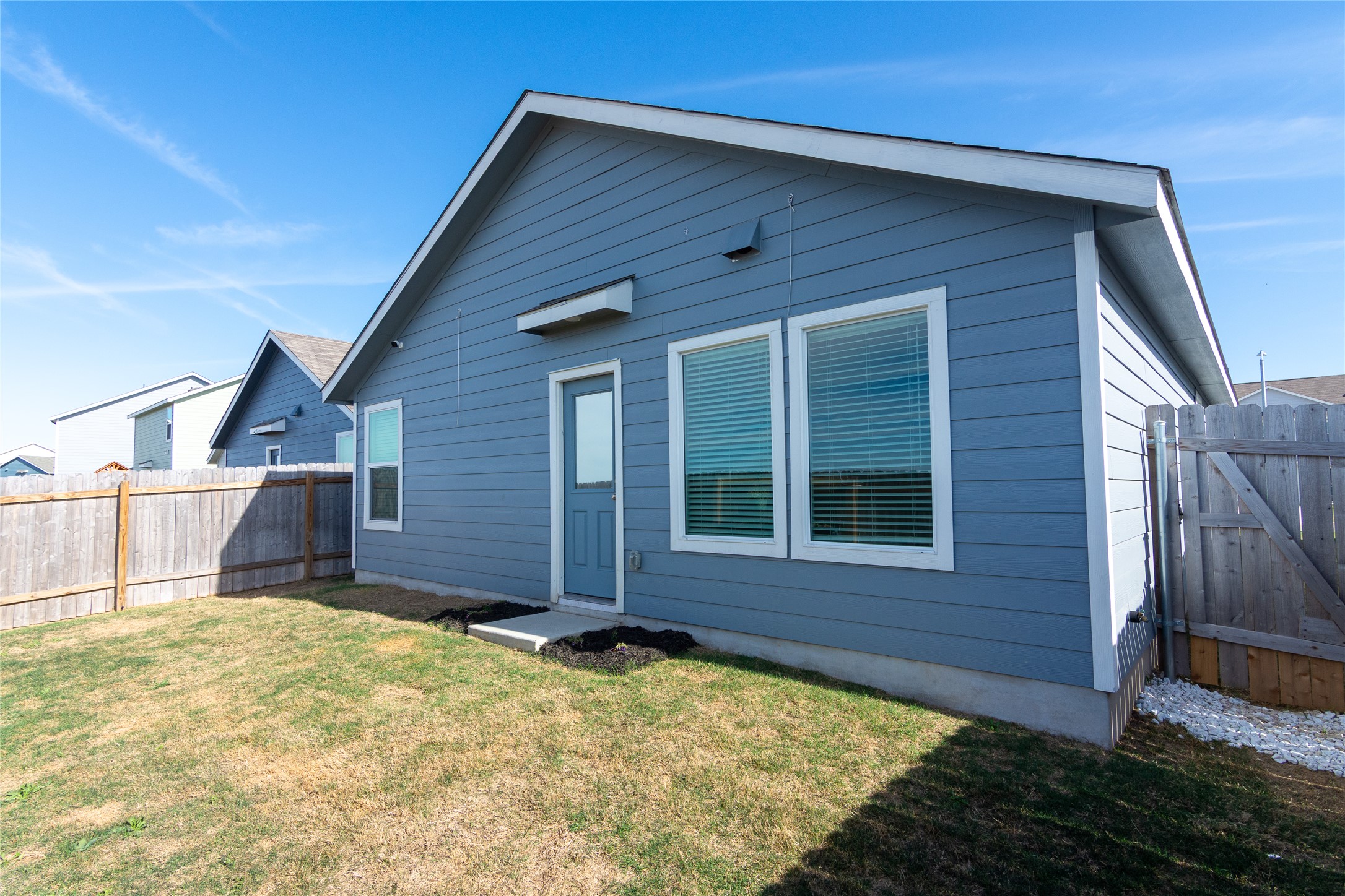 544 Rancho Del Cielo Loop Jarrell, TX 76537 - Photo 27 of 39 Rear view of house with a fenced backyard and a gate
