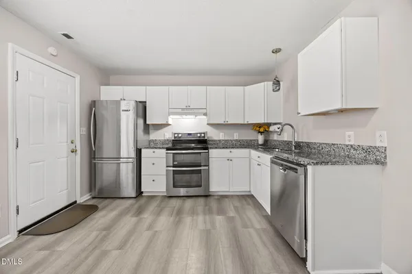 a kitchen with a refrigerator sink and cabinets