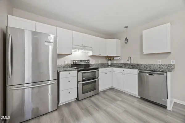 a kitchen with a refrigerator stove and white cabinets