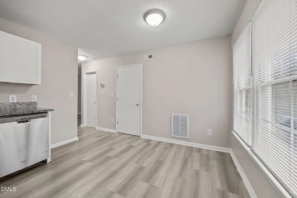 a view of a kitchen with a sink and dishwasher a refrigerator with wooden floor