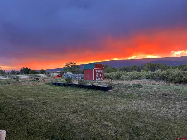 a view of a barn in the middle of a field