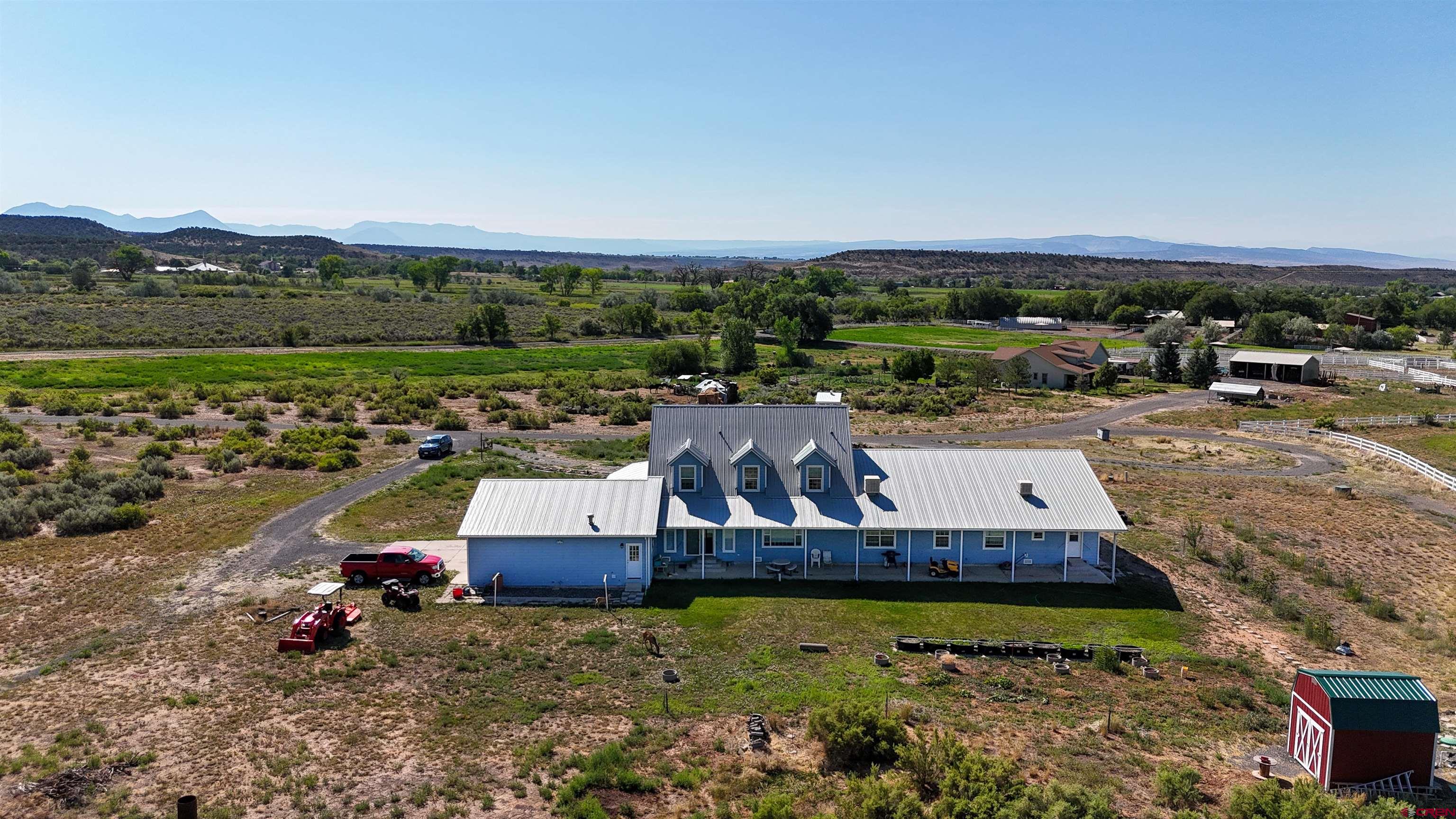 1552 Southwest Painted Fork Road Cedaredge, CO 81413 - Photo 3 of 45 an aerial view of a house with a garden and lake view