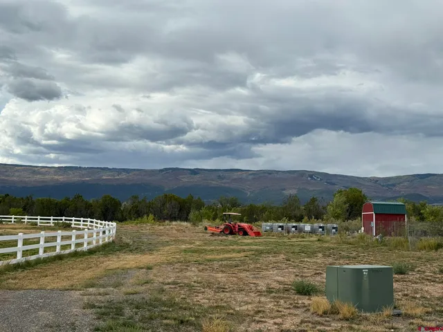 a view of a house with a big yard and sitting area