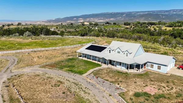 an aerial view of a house with a garden and lake view