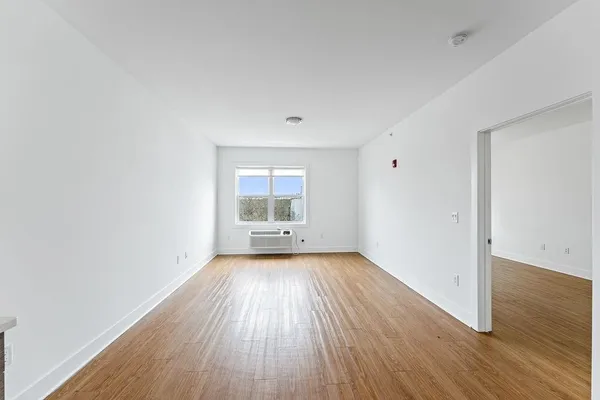 a view of a room with wooden floor and window