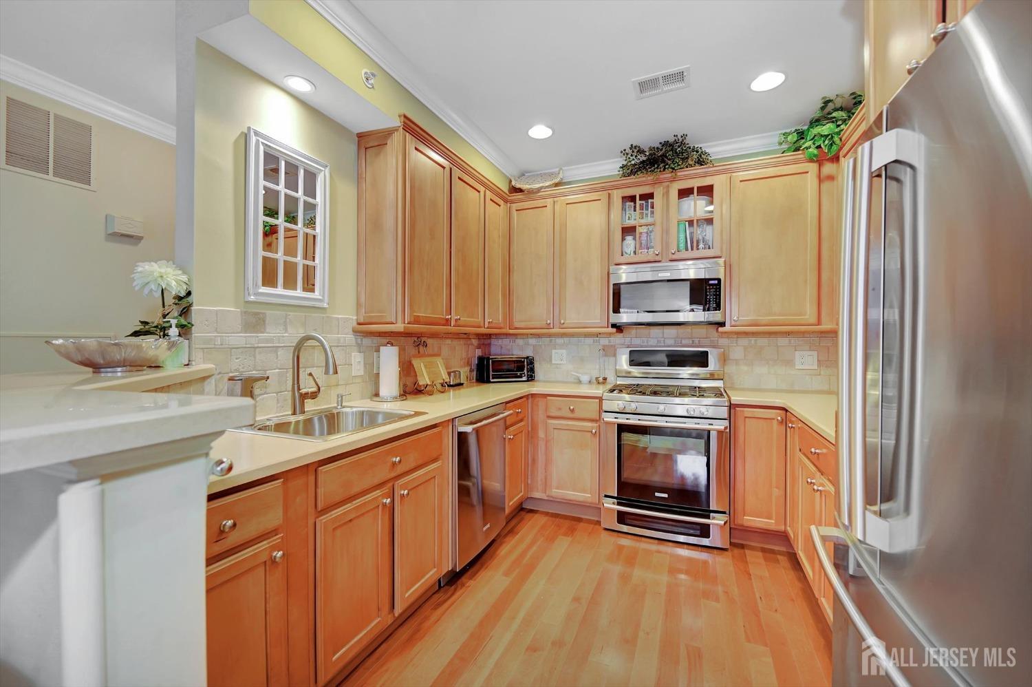 1322 Falston Circle Old Bridge, NJ 08857 - Photo 6 of 38 a kitchen with stainless steel appliances granite countertop a refrigerator a stove and a sink with wooden floor