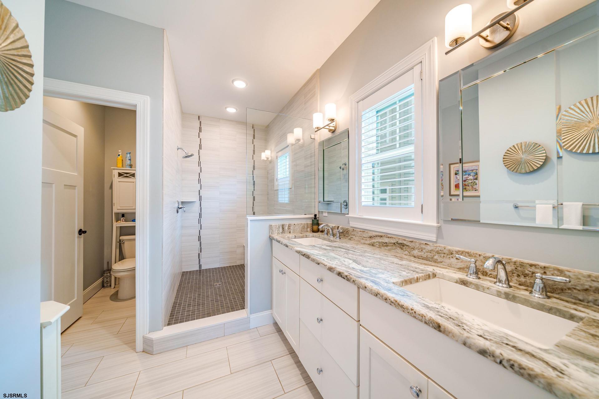230 West Seaspray Road Ocean City, NJ 08226 - Photo 13 of 45 a spacious bathroom with a granite countertop sink mirror and a shower